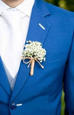 a man in a blue suit with a boutonniere on his lapel