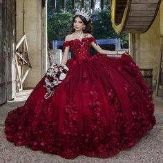 a woman in a red dress with flowers on the skirt and tiara is posing for a photo