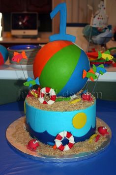 a birthday cake with an inflatable beach ball on top