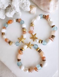 These one of a kind beautifuly ornate beach inspired bracelets was definitely designed for the beach lover accenting a beautiful gold starfish with stunning blue seaglass beads and sunset orange sunstone will definitely give all the beachy vibes when you wear this bracelet. These handcrafted bracelets are all one of the kind bracelets, so once they are gone they are gone.  This bracelet features:  1 bracelet size 7" stretch style  Unique Antique gold brass gold filled coated  blue and white sea Cute Beachy Bracelets, Shell Bracelet Ideas, Ocean-inspired Beaded Bracelets For Beach Season, Handmade Ocean-inspired Beaded Bracelets For Beach Season, Ocean-inspired Starfish Beaded Bracelets For Beach, Vacation Ocean-inspired Shell Beaded Bracelets, Ocean-inspired Shell Bracelets For Beach, Coastal Bracelet, Ocean Accessories