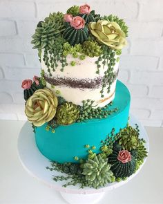 a three tiered cake decorated with succulents and flowers