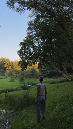 a person standing in the grass near a stream