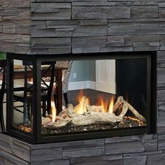 an outdoor fireplace with logs burning inside