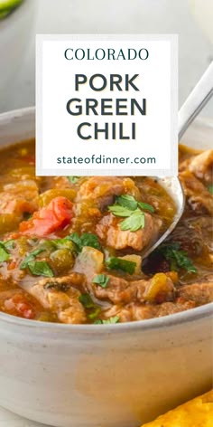 a white bowl filled with pork and green chili next to tortilla chips on the side