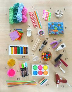 an assortment of craft supplies laid out on top of a wooden table with markers, crayons and pencils