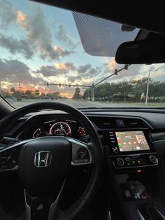 the interior of a car with an electronic display and steering wheel view through the windshield