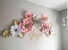 the wall is decorated with paper flowers and gold foil lettering that says gorgia