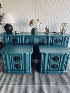 a set of four blue sideboards with drawers and vases on top of them