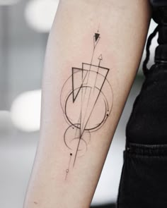 a woman's arm with an arrow tattoo on the left side of her arm