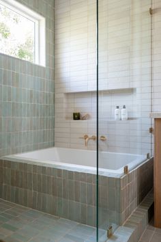 a bath tub sitting next to a window in a bathroom