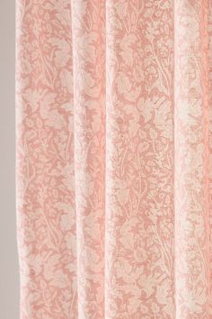 a pink curtain with white flowers on it