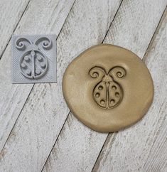 a metal stamp with a ladybug on it next to a rubber stamp pad