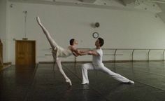 two ballerinas are performing in an empty room