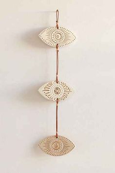 three decorative wall hangings on a white wall