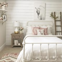 a white bed with pink and white pillows