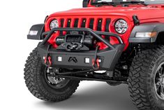 the front view of a red jeep with its lights on and four wheel drive suspensions