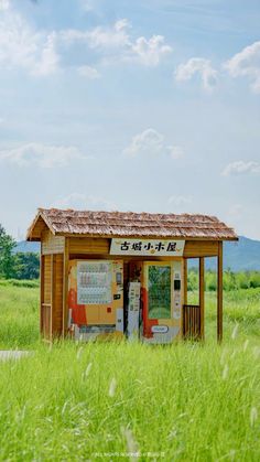 an outhouse in the middle of a grassy field