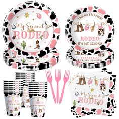 a set of pink and black dinnerware with cow print on the plates, forks, napkins and utensils