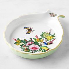 a white bowl with flowers and butterflies painted on it