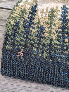 a knitted hat sitting on top of a wooden table