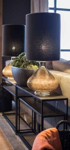 two lamps sitting on top of a table next to a couch