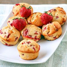 strawberry muffins on a white plate with fresh strawberries in the middle,