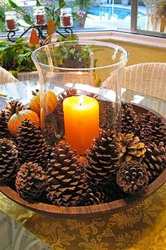 a table topped with pine cones and a candle