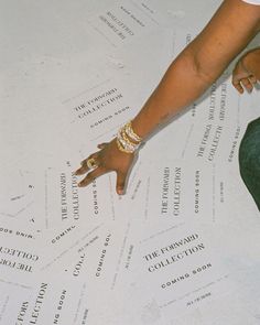 a person's hand on top of a large sheet of paper with words all over it