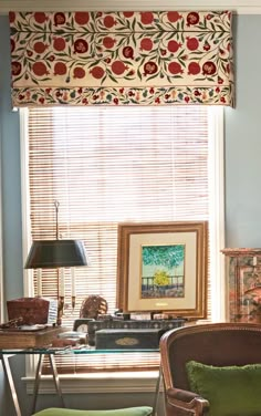 a living room filled with furniture and a window covered in roman blind shades on the windowsill