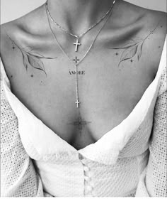 a woman wearing a cross and leaf tattoo on her chest