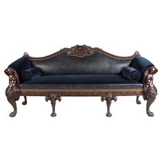 an ornately carved couch with blue velvet upholstered on the back and arms