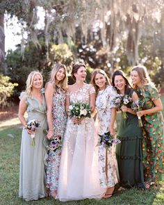 a group of women standing next to each other on top of a lush green field