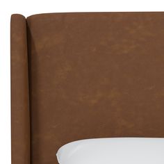 an upholstered headboard with white pillows and brown leather finish on the top