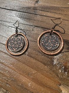 These copper dangle earrings consist of a 2cm round charm that has an etched baroque design on it, which hangs inside of a larger hammered copper ring (2.7cm).  Not only do these earrings look great, but they sound great. The hanging central charm makes a beautiful little jingle jangle sound when it taps against the outer ring as you move your head. It's nothing to distracting, it's just a nice and subtle detail.  These earrings have a small amount of weight to them due to their amount of copper Artisan Small Hoop Copper Jewelry, Nickel-free Small Hoop Copper Jewelry, Artisan Copper Dangle Hoop Earrings, Hand Forged Copper Hoop Earrings With Dangle, Nickel-free Rust Drop Earrings, Hand Forged Copper Dangle Hoop Earrings, Nickel-free Rust-colored Metal Jewelry, Artisan Nickel Free Copper Hoop Earrings, Small Hoop Copper Jewelry