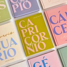 several different colored books on a white surface with the words ca pru cor nio written in cursive writing