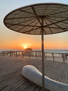 the sun is setting over the beach and boardwalks