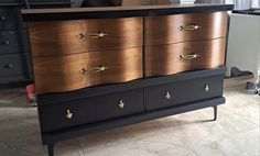 a black and gold dresser sitting on top of a tiled floor