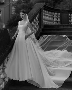 a woman in a wedding dress standing on stairs