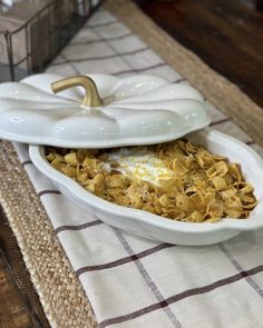 a white bowl filled with food sitting on top of a table next to a napkin