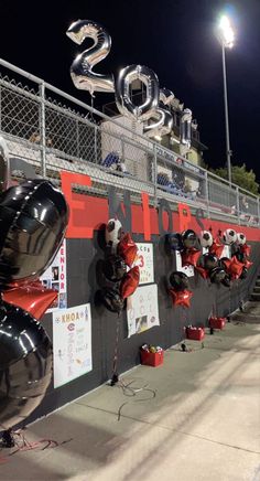 balloons are lined up on the side of a wall with numbers and signs attached to it