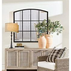 a living room with a couch, chair and large mirror on the wall above it