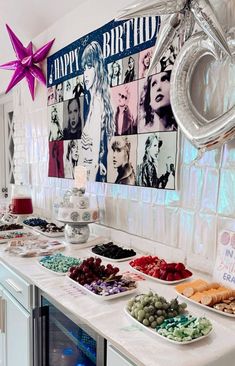 a buffet with lots of food on it and balloons hanging from the ceiling above them