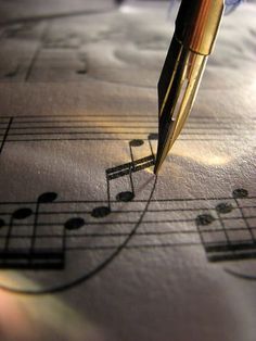 a pen sitting on top of music notes