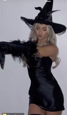 a woman in a black dress and witch hat