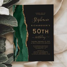 a black and gold 50th birthday party card with greenery on the front, featuring an emerald green background