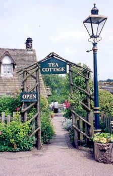 the entrance to tea cottage is surrounded by greenery and an old fashioned lamp post