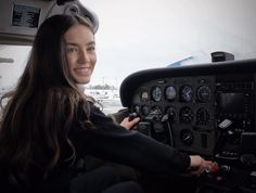 a woman sitting in the cockpit of an airplane