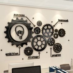 an office with gears on the wall and a laptop on the desk in front of it