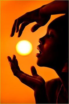 a woman holding her hands up to the sun