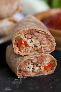 two burritos cut in half on a table